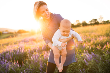 young mother in nature with baby son in the arms.