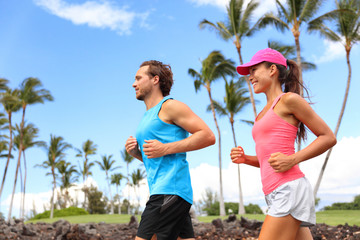 Wall Mural - Happy couple running together training in morning summer living a healthy lifestyle. Interracial people working out in summer park.