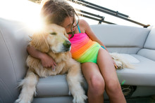 Girl Sitting With Arm Around Golden Retriever Dog 