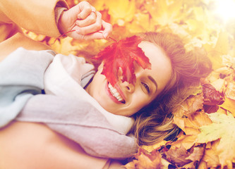 Wall Mural - beautiful happy woman lying on autumn leaves