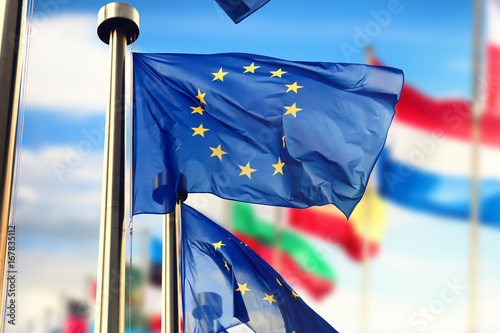 Fotografía EU flags waving over blue sky. Brussels, Belgium