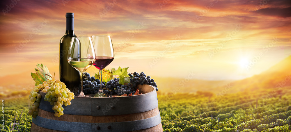Bottle And WineGlasses On Barrel In Vineyard At Sunset
 - obrazy, fototapety, plakaty 