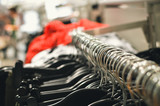 Fototapeta  - Close up on trendy clothes shop hangers. Costume dress fashionable store, stylish concept background