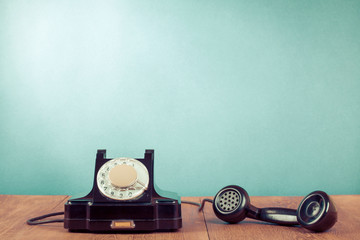 Fototapete - Retro rotary telephone on table in front mint green background. Old instagram style filtered photo