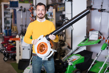 Wall Mural - Young man choosing leaf blower