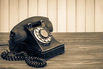 Fototapete - Old retro telephone on table. Vintage style sepia photo