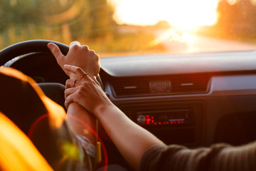 Couple driving car on way to sunset