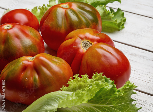 Red tomatoes and salad on white wooden board Poster