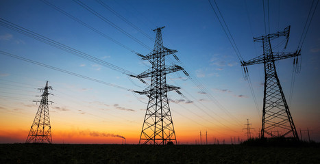 silhouette of electricity pylons and high-voltage power lines on the field at sunset. wire electrica