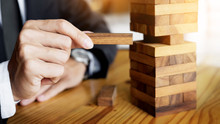 Planning, Risk And Wealth Strategy In Business Concept, Businessman And Insurance Gambling Placing Wooden Block On A Tower