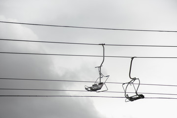 Empty chairlift with cloudy sky in the background