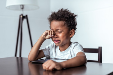 Wall Mural - boy crying while sitting with tablet