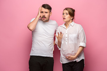 Wall Mural - The funny surprised handsome man and his beautiful pregnant wife's tummy