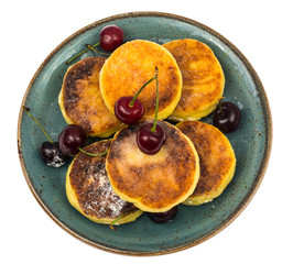 Sweet cottage cheese pancakes with powdered sugar on plate on wh