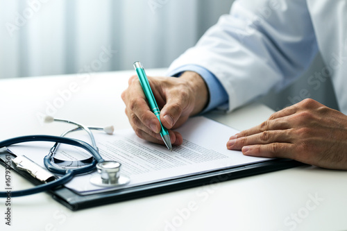 Fotomural doctor writing documents at desk in clinics office