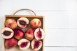 Nectarines on a tray on a white table. Flat lay. Top view. Copyspace