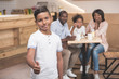 © LIGHTFIELD STUDIOS - african-american boy showing thumb up with his family blurred on background