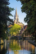 Belgium, West Flanders (Vlaanderen), Bruges (Brugge). Spire Of Church Of Our Lady, Onze-Lieve-Vrouwekerk Behind Canal.