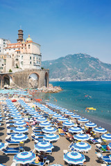 Amalfi town and summer Atrani beach with umbrellas , Italy