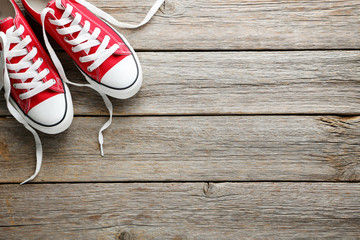 Wall Mural - Pair of red sneakers on grey wooden table