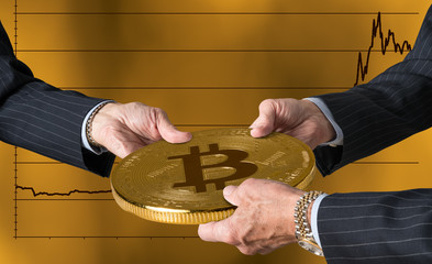 Three traders hands holding large bitcoin