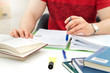 © terovesalainen - Young athletic man and student studying and writing notes in public or school library in college or university. Stack and pile of books, pen and paper on table.