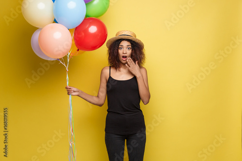 Cuadros en Lienzo Celebration Concept - Close up Portrait happy young beautiful african woman in black t-shirt surprising with colorful party balloon