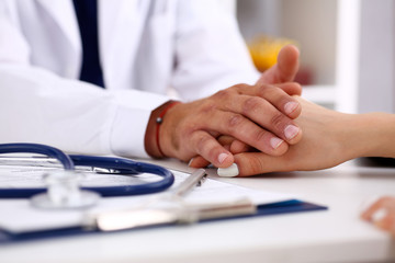 Wall Mural - Friendly male doctor hold female arm in office