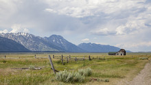 Moulton Barn Located In Mormon Row, Gros Ventre River Valley In Grand Teton National Park And Active Cloudy Sky In Background