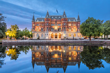 Fototapete - Orebro city in Sweden. Beautiful old building from 19th century in the evening, architectural landmark located on the embankment of Svartan river.