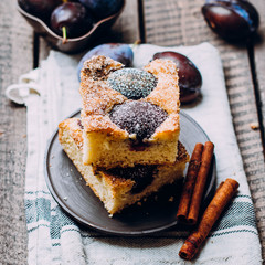 Wall Mural - Homemade pie with plums on the wooden table background. Fruit autumn cake with cinnamon. 