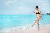 Fototapeta  - Beautiful young woman on sea beach at resort