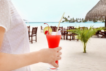 Wall Mural - Young woman with tasty cocktail at resort