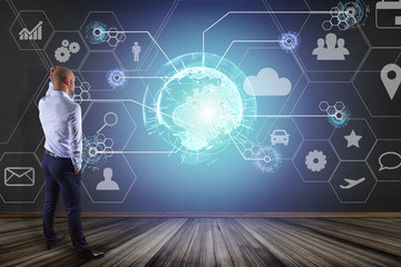 Poster - Businessman in front of a wall with an International business network connection displayed on a futuristic interface with technology icon and sphere globe - Worldwide business concept