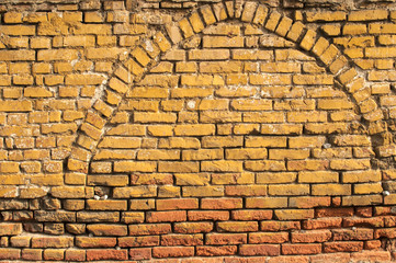 Old grunge weathered vintage crumbling brick wall closeup as background