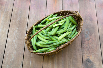 Basket with peas/Basket with peas on wooden background