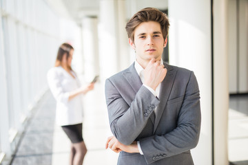 Young handsome business man hands on chin in front of business woman. Business team