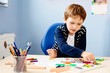 © Daniel Jędzura - Child draws a pastel drawing of his teacher in school class.