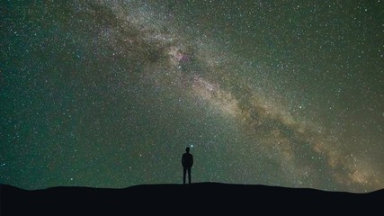 Wall Mural - The man stand on a background of a milky way with asteroids skyfall. time lapse