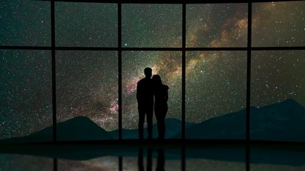 Wall Mural - The man and woman stand near a window against the starry sky. time lapse