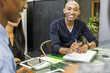 © Adam Hester/Blend Images - Smiling man with notebook in meeting