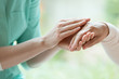 Caretaker massaging pensioner's hand