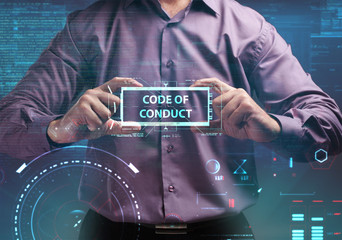 Business, Technology, Internet and network concept. Young businessman working on a virtual screen of the future and sees the inscription: Code of conduct