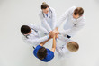 © Syda Productions - group of doctors with hands together at hospital