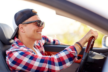 Wall Mural - happy young man in shades driving convertible car