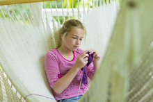 Caucasian Girl Laying In Hammock And Knitting