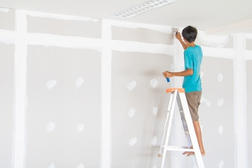 worker male on stair is putting  gypsum plaster interior decoration of home wall