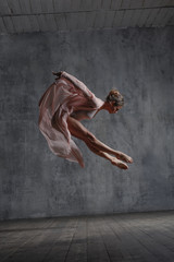 Young beautiful dancer is posing in studio