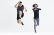 © Blue Jean Images - Portrait of young couple jumping against white background