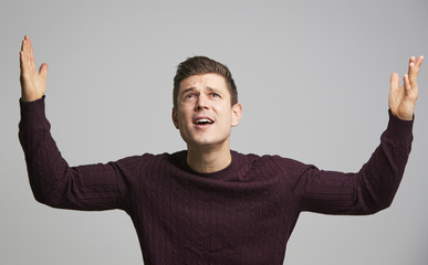 Wall Mural - Portrait of a shocked young white man with arms in the air